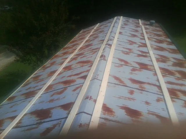 Rusted metal roof panels with new wood purlins before replacement — Storm Damage Roof Repair in Marydel by Roofing Brothers
