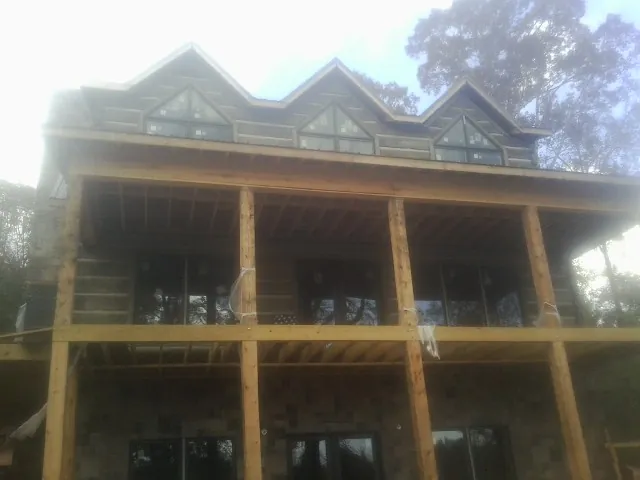 Dormers and porch framing on a large log home under construction — Roof Coating work by our crew in Marydel